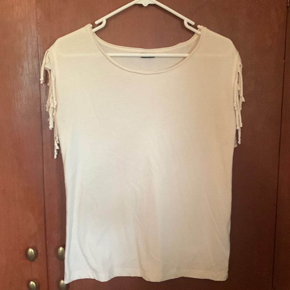 Sleeveless ivory shirt with fringed bead detailing.